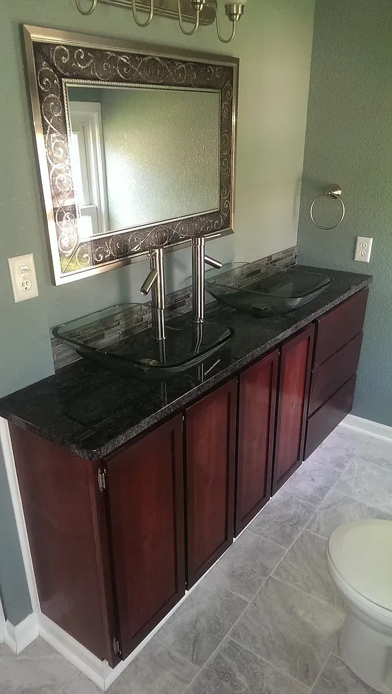 Bathroom — dark cherry double vanity with glass vessel sinks and granite countertop