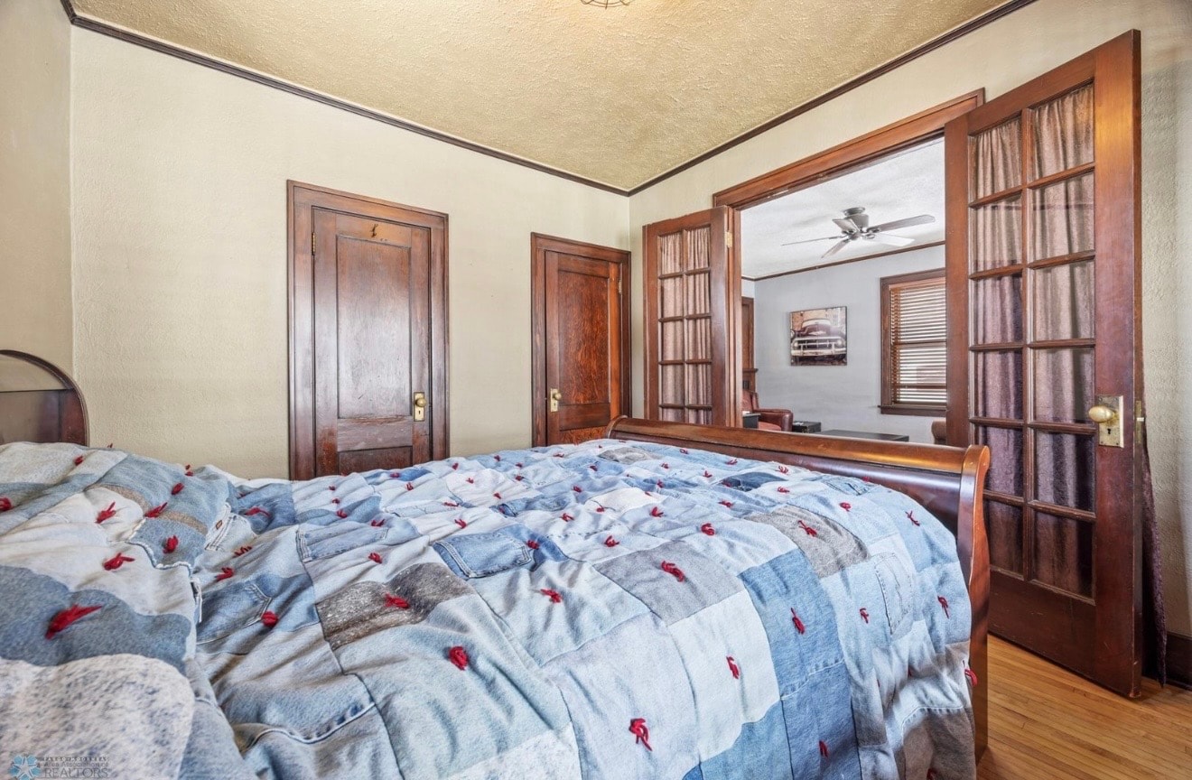 Bedroom — craftsman with original wood trim, French doors and hardwood floors