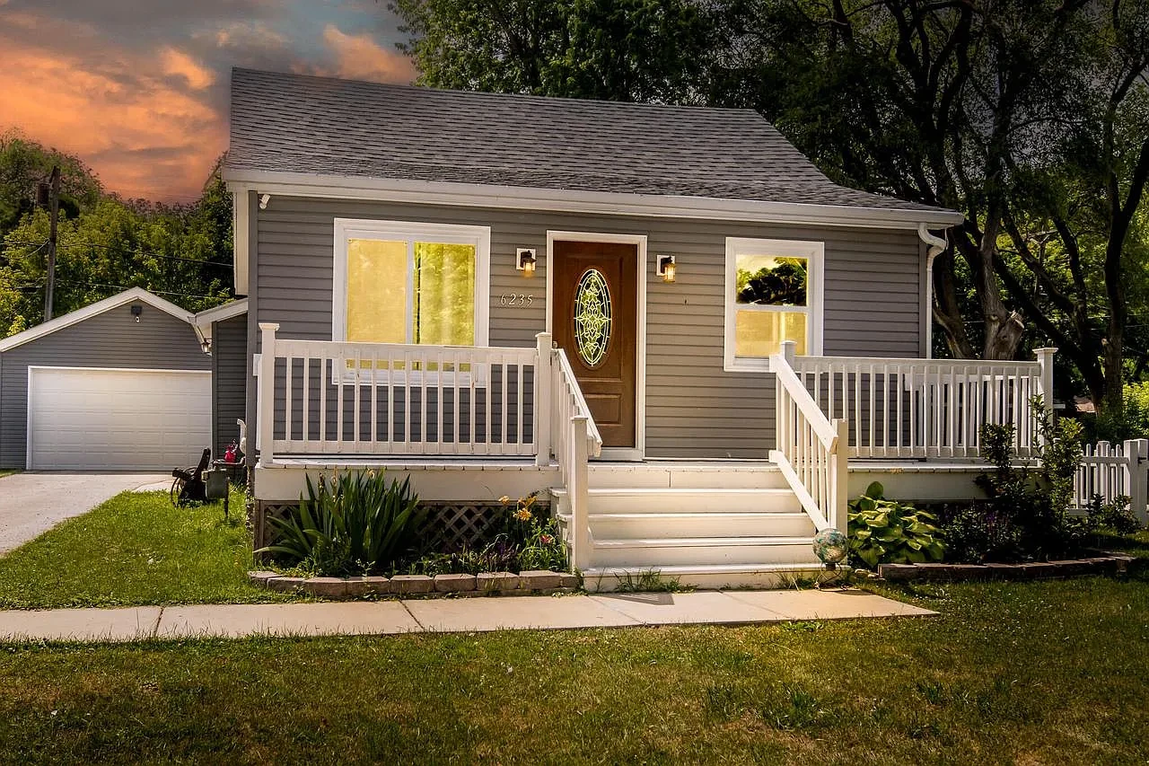Exterior — gray bungalow with white porch at sunset