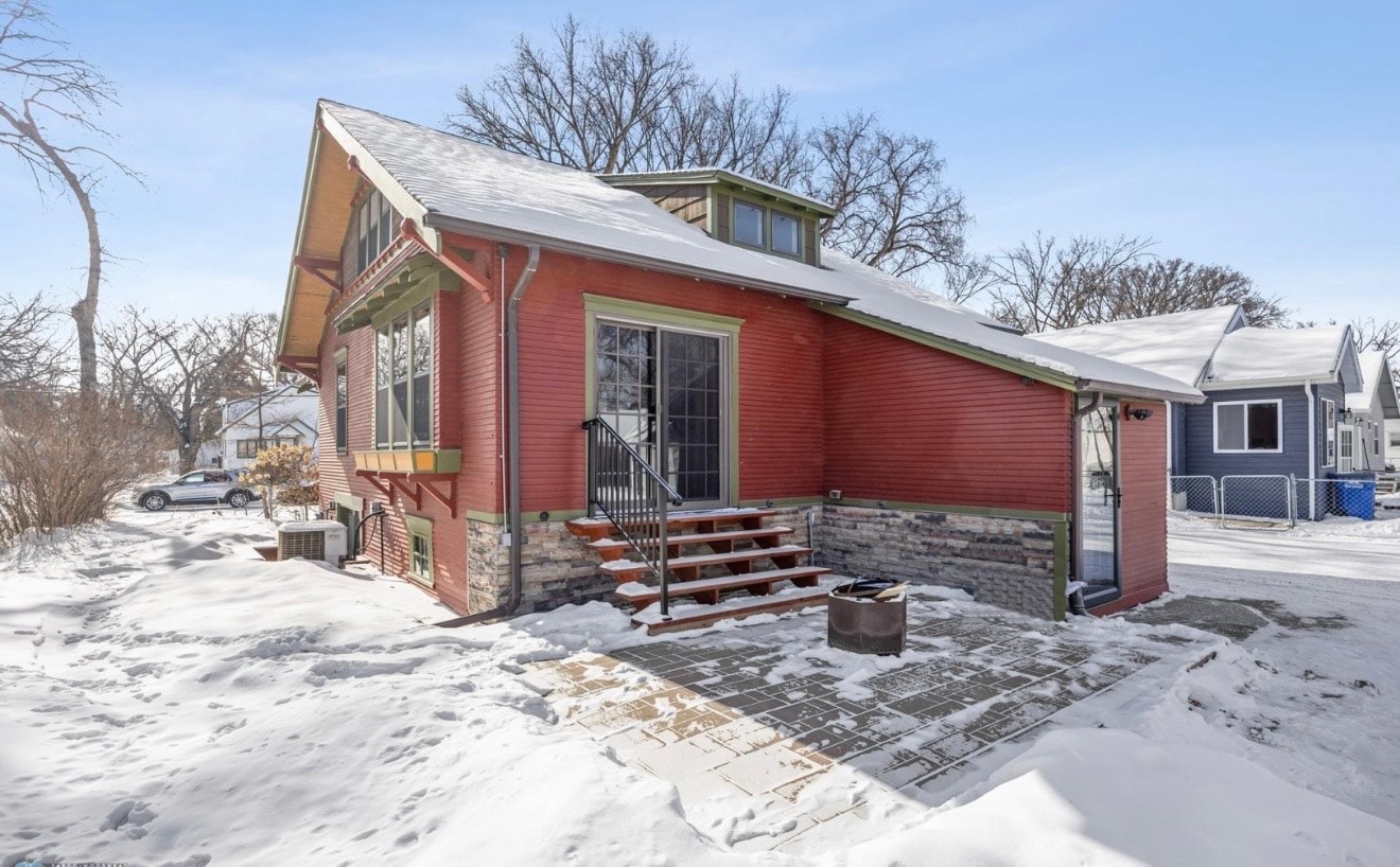 Exterior — red craftsman home with stone foundation and patio, winter