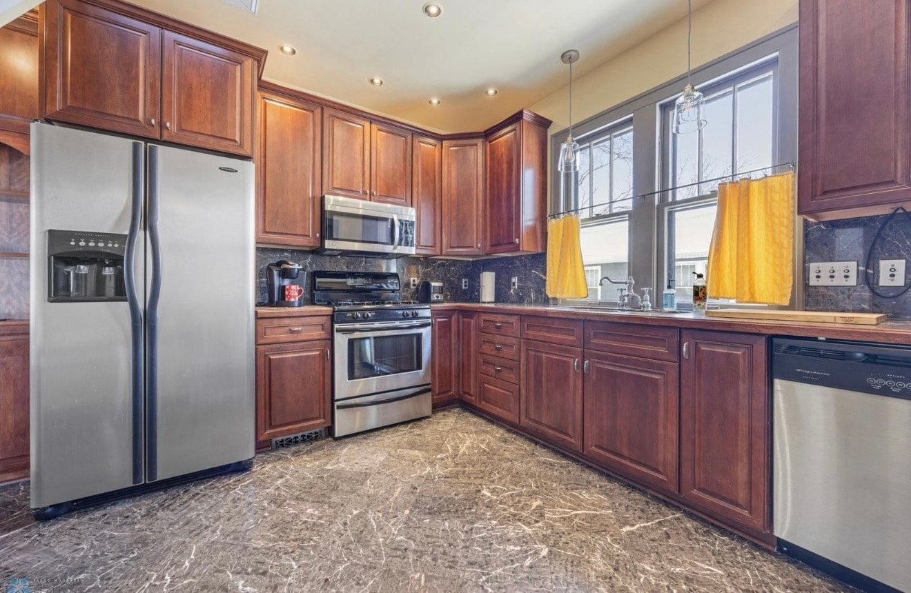 Kitchen — wide view with cherry cabinets, stainless appliances, yellow curtains and marble floor