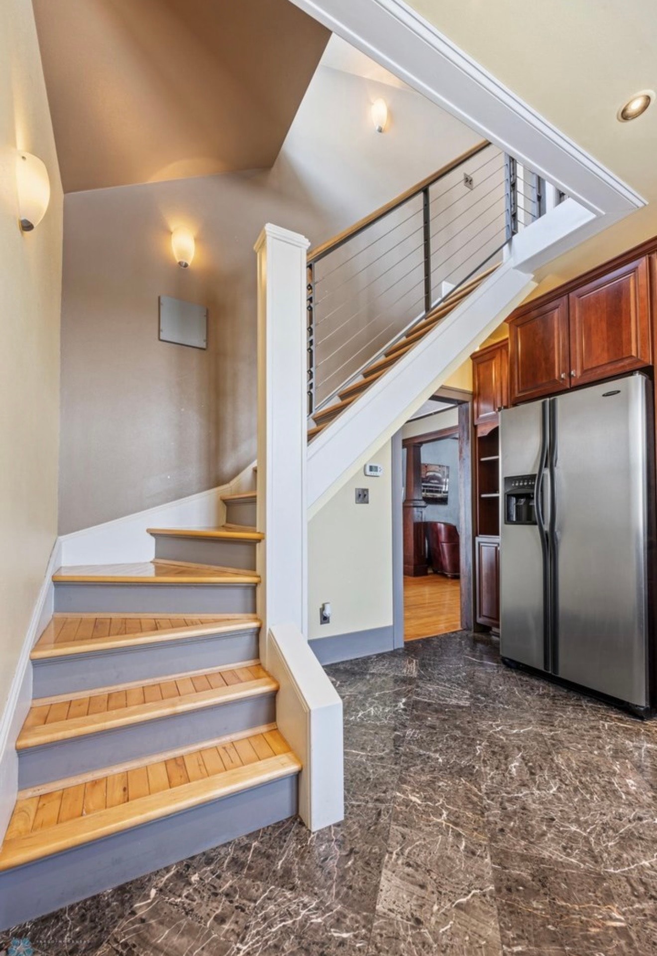 Staircase — cable railing with marble tile floor and cherry wood trim